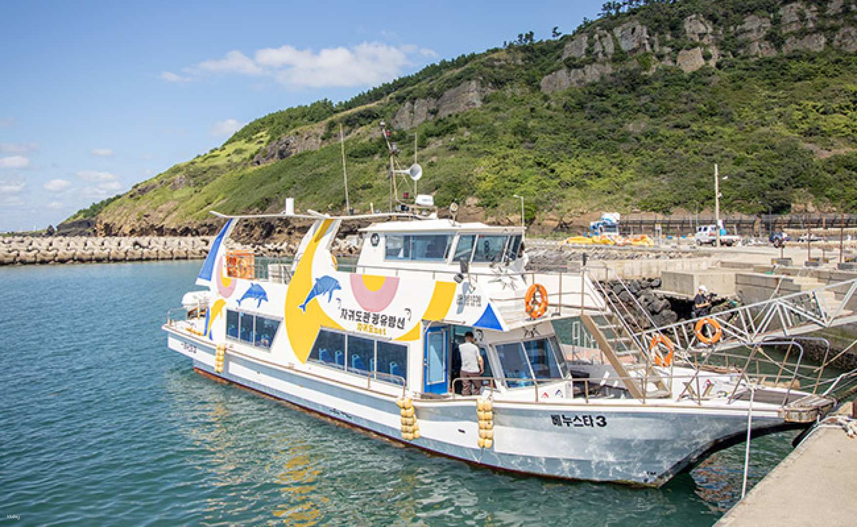 Explore the serene waters of Jeju Island aboard a colorful boat ready to create unforgettable fishing memories amid stunning coastal views and the thrill of the catch.